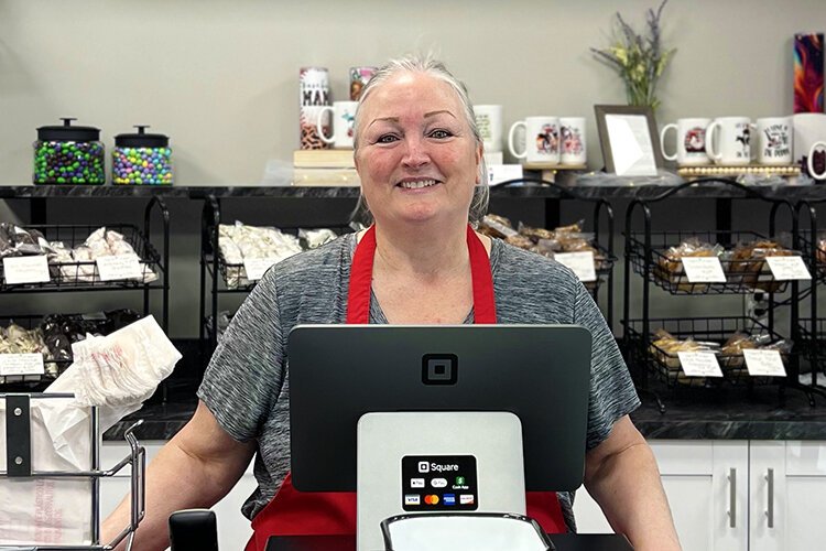 Beth Welser poses for a photo at her newly-opened sweet shop, Dot's Candy Bar.