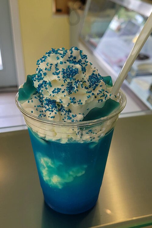 Scoops of Lexington's Shark Attack is a tangy blue raspberry slush with vanilla hand-dipped ice cream topped with blue shark gummies, whipped cream, and sprinkles.