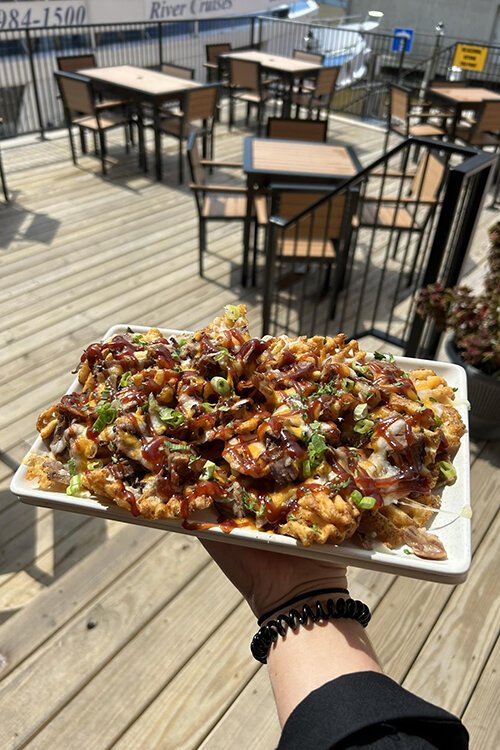 One of the establishment's most popular appetizers, the Bootleggers Fries are topped with brisket, melted cheese, barbecue sauce, and green onions.