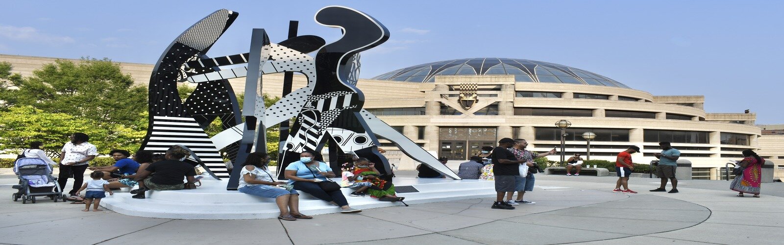 People lounge outside the Charles H. Wright Museum of African American History during the African World Festival in Detroit, Michigan.