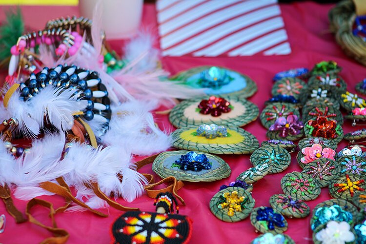 Handmade jewelry made with feathers, beads, and various colored gems.