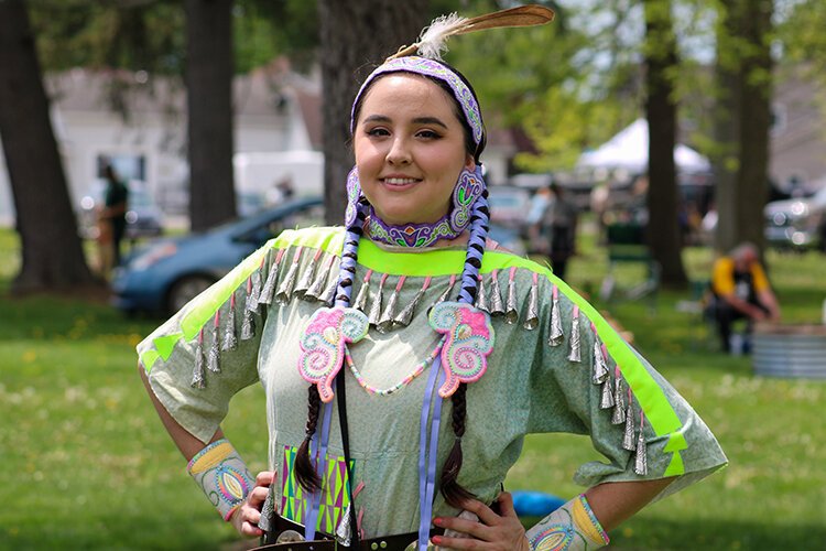 A Women's Jingle Dress dancer takes a break after her dance.