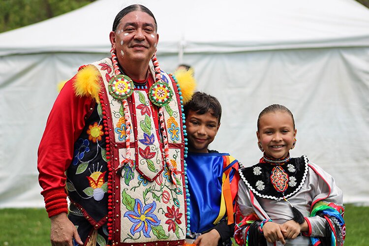 A grandfather poses for a photo with his grandchildren during Clay Days on Saturday, May 13, 2023.