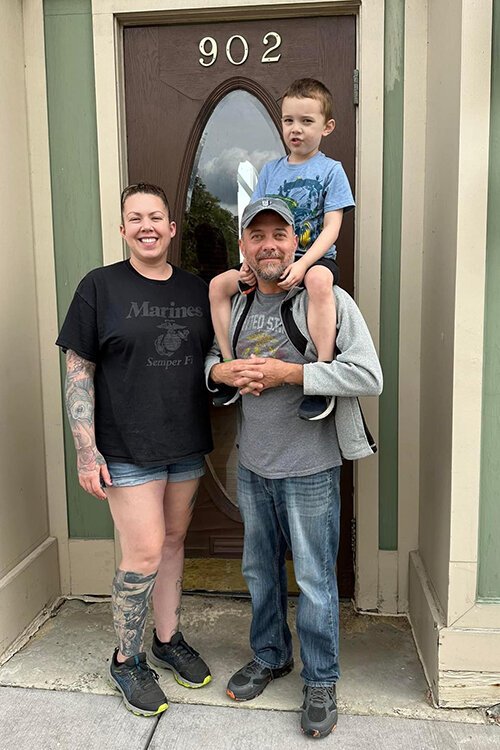 Rob and Hannah Cowan pose for a photo with their son Mikey in front of their business Belle River Winery's new location in Port Huron.