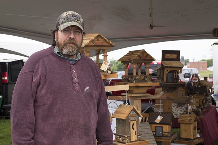 Ken Soulliere, woodcrafter and owner of Bird is the Word, poses for a photo in front of his booth at Vantage Point Farmers Market on Saturday, May 22, 2021.