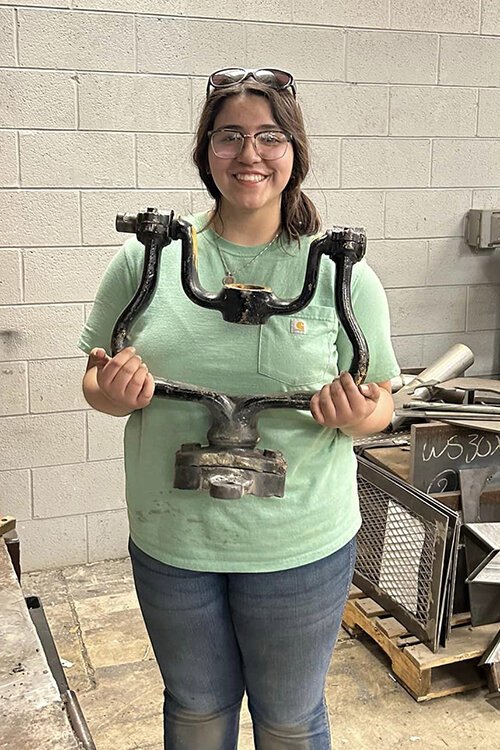 St. Clair County Community College welding student Gabby Lulis poses for a photo with the bell holder for the D.B. Harrington.