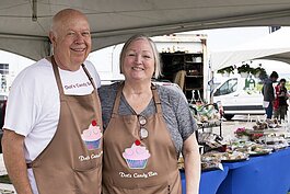 Owner of Dot's Candy Bar LLC, Beth Welser, and her husband Herb pose for a photo at their booth at Vantage Point Farmers Market on Saturday, May 22, 2021.