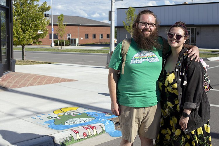 Eddie Lee and Megan Strachan pose for a photo with Strachan’s mural on Michigan Street in Port Huron.
