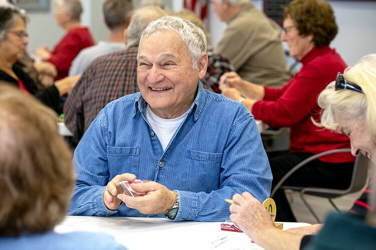 Walter plays euchre at the St. Clair County Council on Aging where dozens of community members have gathered to play together.