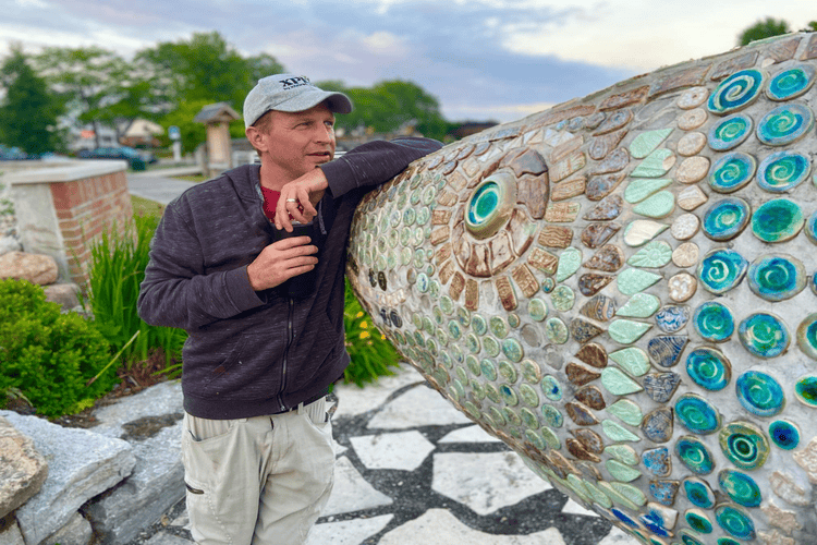 Art advocate and educator Jason Stier poses with Wally the Walleye, a public art piece crafted by dozens of Blue Water Area residents of all ages.