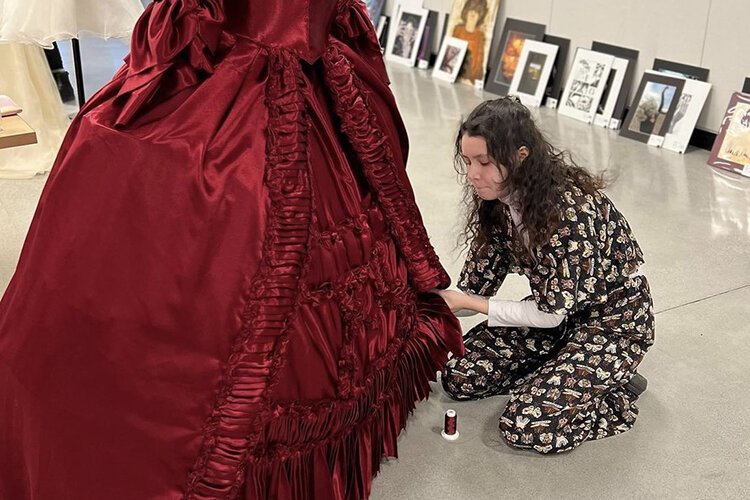 Kaylee Kruse makes an adjustment to her dress which received recognition in the Scholastic Arts and Writing Awards.
