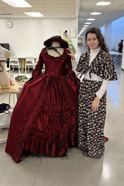 Kaylee Kruse poses for a photo next to her award-winning dress which is on display at the College for Creative Studies in Detroit, Michigan.