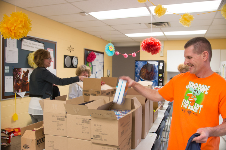 Bill Westerhof chooses food to send home with students on Fridays.