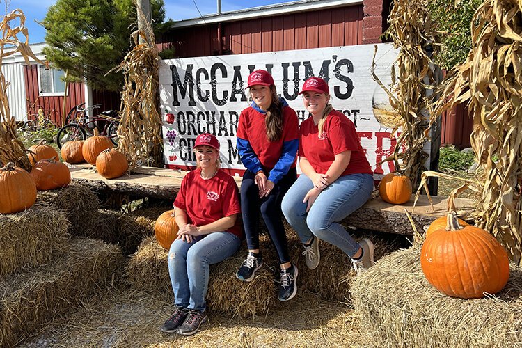 Workers at McCallum's Orchard & Cider Mill pose for a photo outside the storefront.