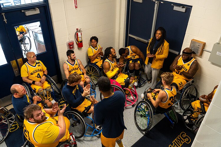 The University of Michigan Wolverines Adaptive Sports Basketball team and Head Coach, Jessica Wynn, go over their game plan at halftime.