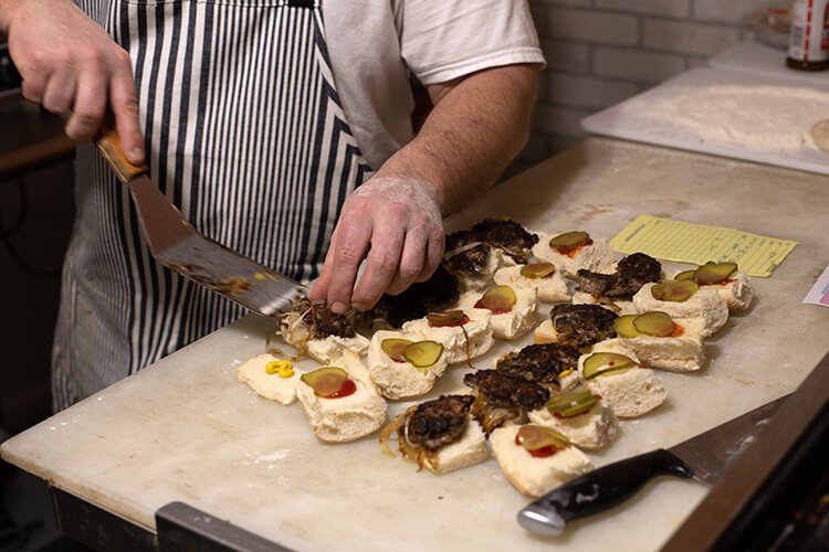 Dale Moses, owner of Sub Sliders and Whiskey Coffee Company, prepares an order of sliders.