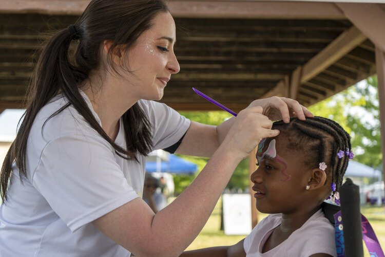Wonder Wolf Entertainment face painting guests at Port Huron's Summer Market Pop-Up on opening day.