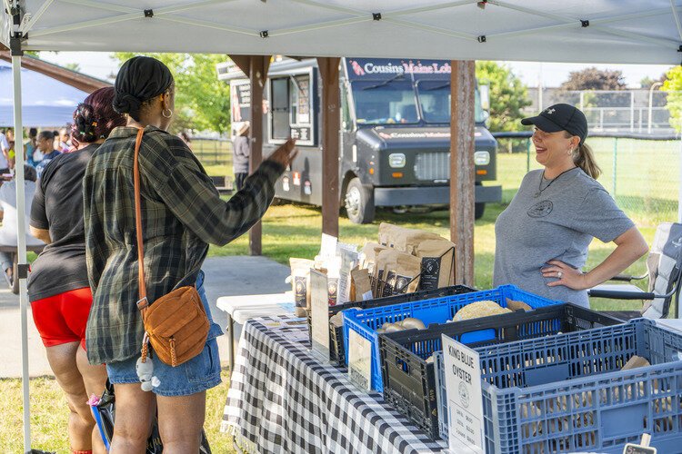 Visitors stop by Down To Earth Mushroom Co, one of the many vendors for the community to discover at the Pop-Up Market.