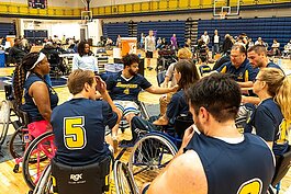 Jordan Scheidecker, Disability Resources Specialist at St. Clair County Community College (SC4) and Head Coach of the college’s wheelchair basketball team, rallies the players during halftime.