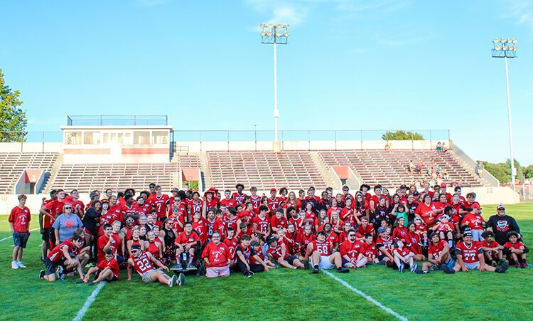 Victory Day staff, players, and participants gather for a team photo after the game.