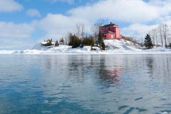 Marquette Lighthouse reflects off clear ice