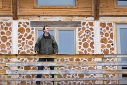 Greg Booth in front of his cordwood home