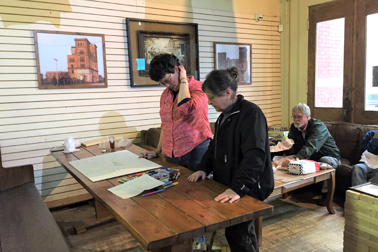 EUP residents Judy Merril-Smith and Annemarie Askwith work on a "Save the Data" sign.