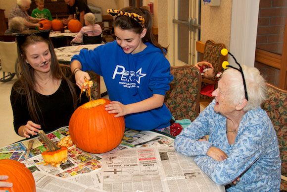 Big Brothers Big Sisters participants carve pumpkins at Eastwood Nursing Home in Negaunee.