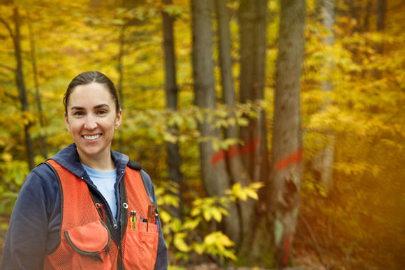 Katie Armstrong stands in front of a red maple clump marked to cut as part of a hardwood thinning.