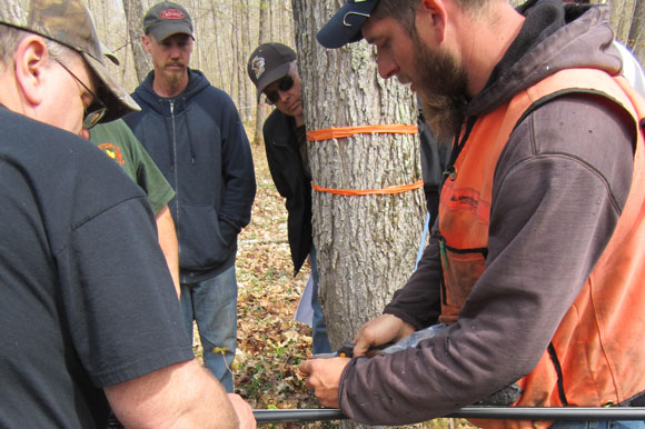 Michigan Maple Farms owner Mike Ross and woods foreman Nate demonstrate running maple sap lines.