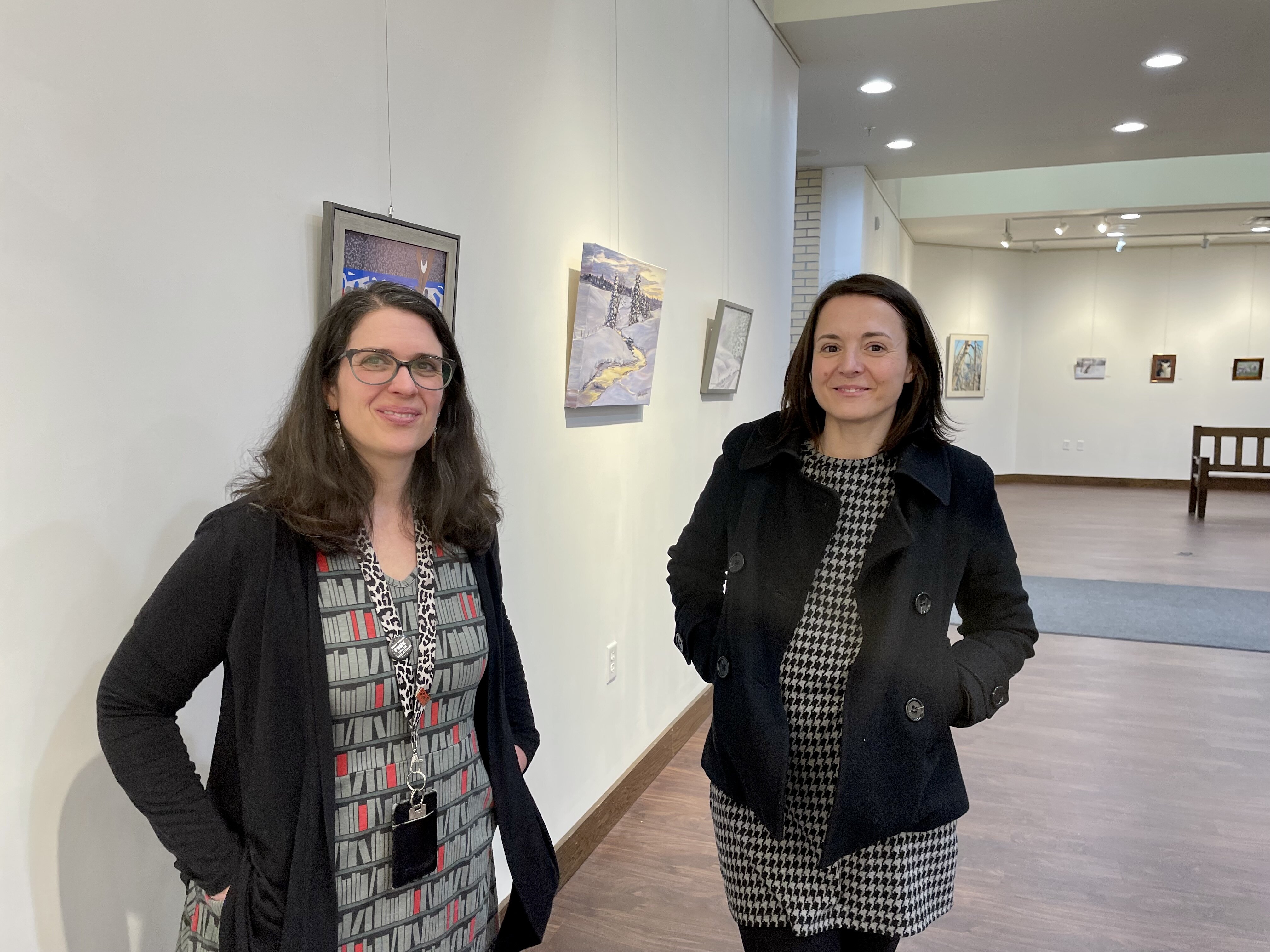 Peter White Public Library Director Andrea Ingmire (left) recently visited with Community Foundation of Marquette County CEO Zosia Eppensteiner in the library’s Huron Mountain Club Art Gallery. 